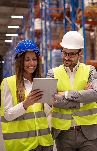 Two warehouse supervisors reviewing a tablet